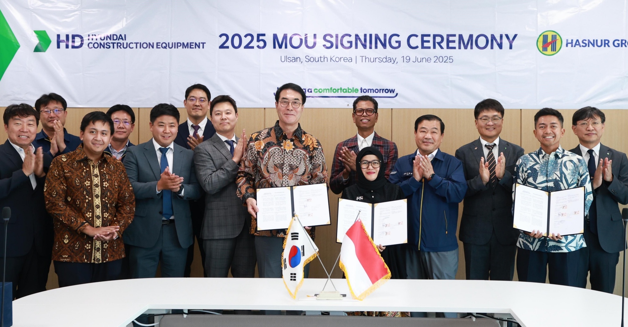 HD현대건설기계 최철곤 사장(앞줄 왼쪽 다섯 번째)과 하스누르 그룹 자얀티 사리 사장(앞줄 왼쪽 여섯 번째)이 19일 울산캠퍼스에서 전략적 업무 협약을 체결한 뒤 기념촬영을 하고 있다.