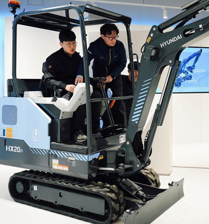 Employees at the HD Construction Equipment’s Eumseong Global Training Center engage in practical training with a mini electric excavator.